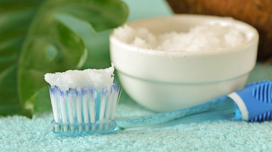 Pyyhkeell oleva hammasharja, johon on laitettu valkoista ruokasoodatahnaa.