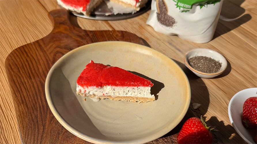 Pala chiacheesecakea mansikoilla lautasella, joka on puualustalla yhdess� pienen chiansiementen kulhon kanssa.