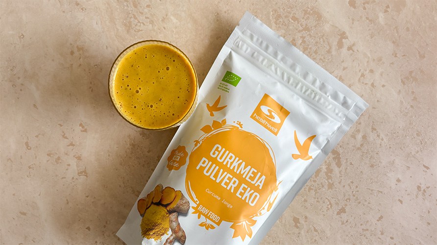 Healthwell Kurkumajauhe Luomu -pakkaus p�yd�ll� yhdess� kurkumasmoothielasillisen kanssa.