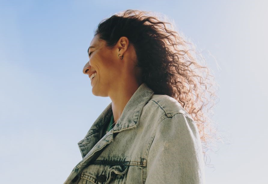 Naurava nainen farkkutakissa.