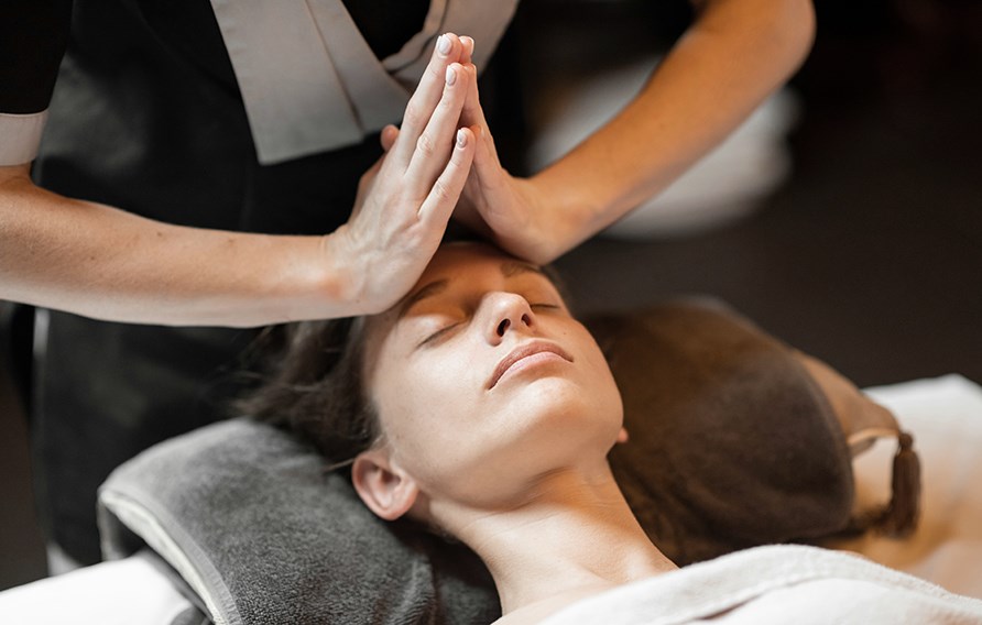 Nainen nauttii kasvojen lymfahieronnasta silm�t suljettuina.